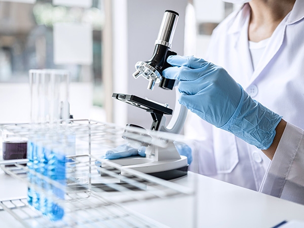 a close up of a scientist with a microscope